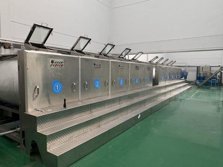 Row of stainless-steel malaxer units on the processing line